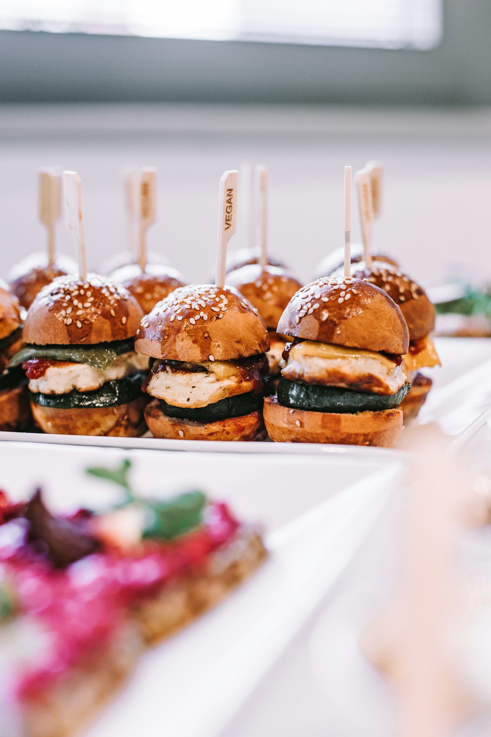 A platter of mini burgers held together with skewers